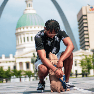 st. louis dog owner with small dog by gateway arch