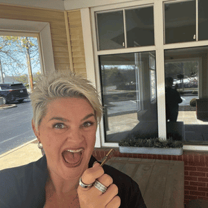 Janie Budnick holding key to Cattails Luxury Cat Lodge in St. Louis, MO